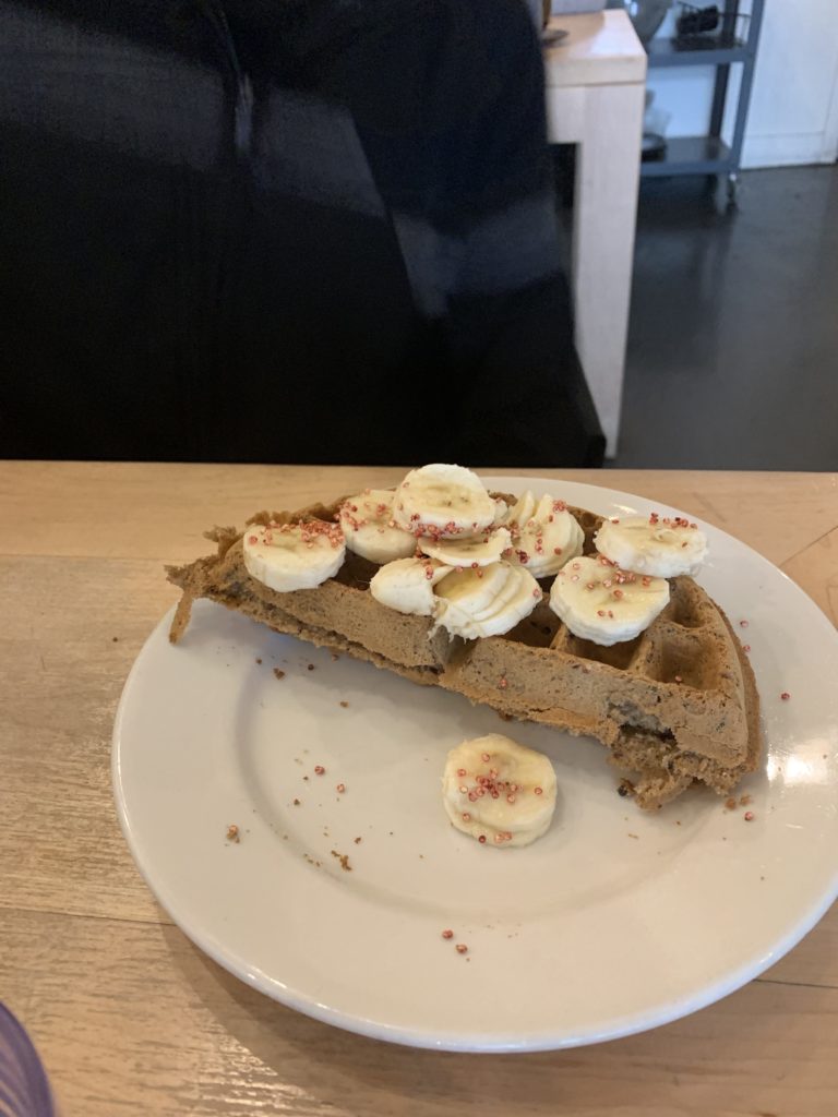 Quinoa waffle - coconut, almond flour, oat flour, coconut sugar, topped with bananas and maple syrup.